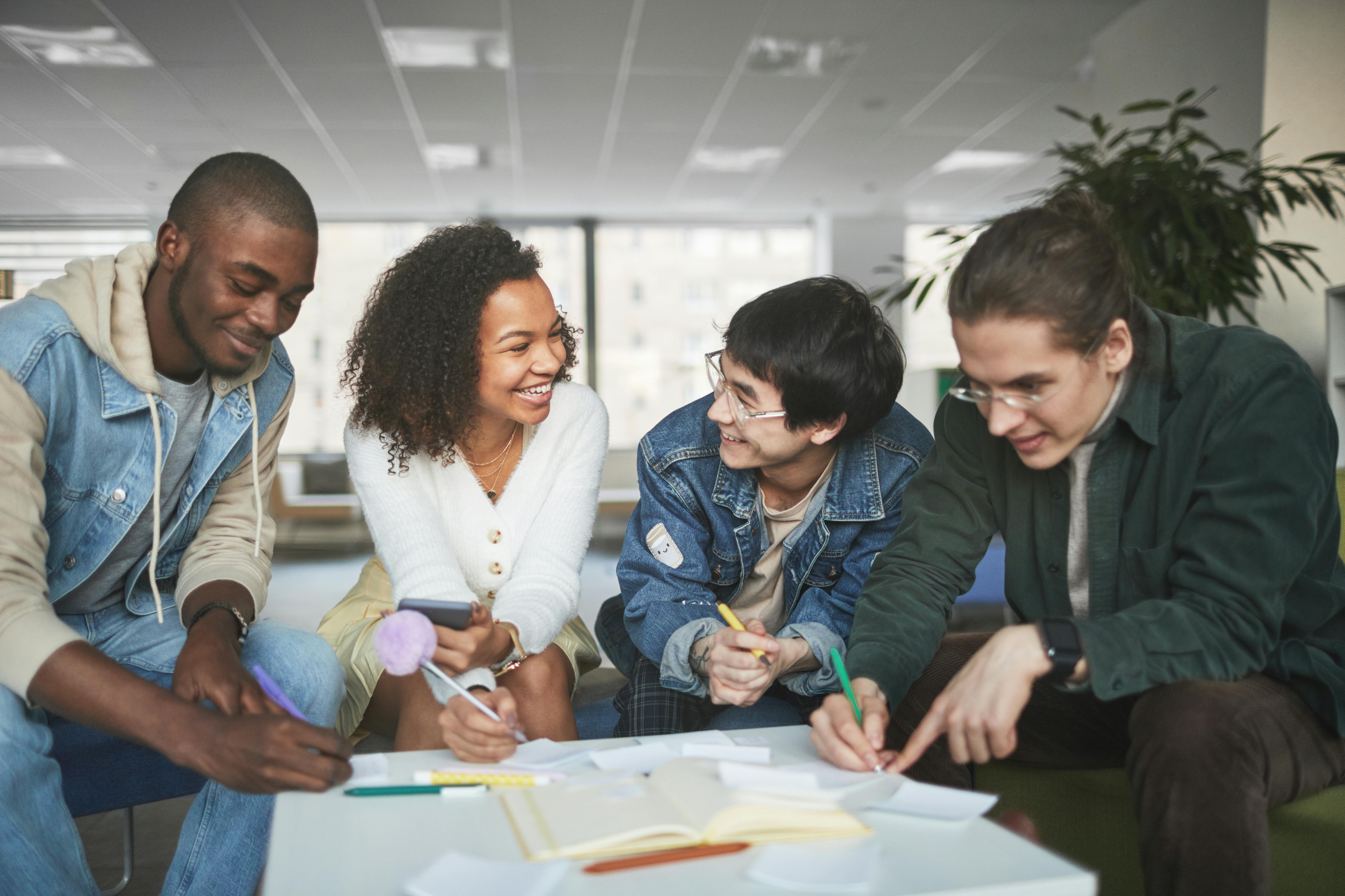 Students gathering in a group looking at papers