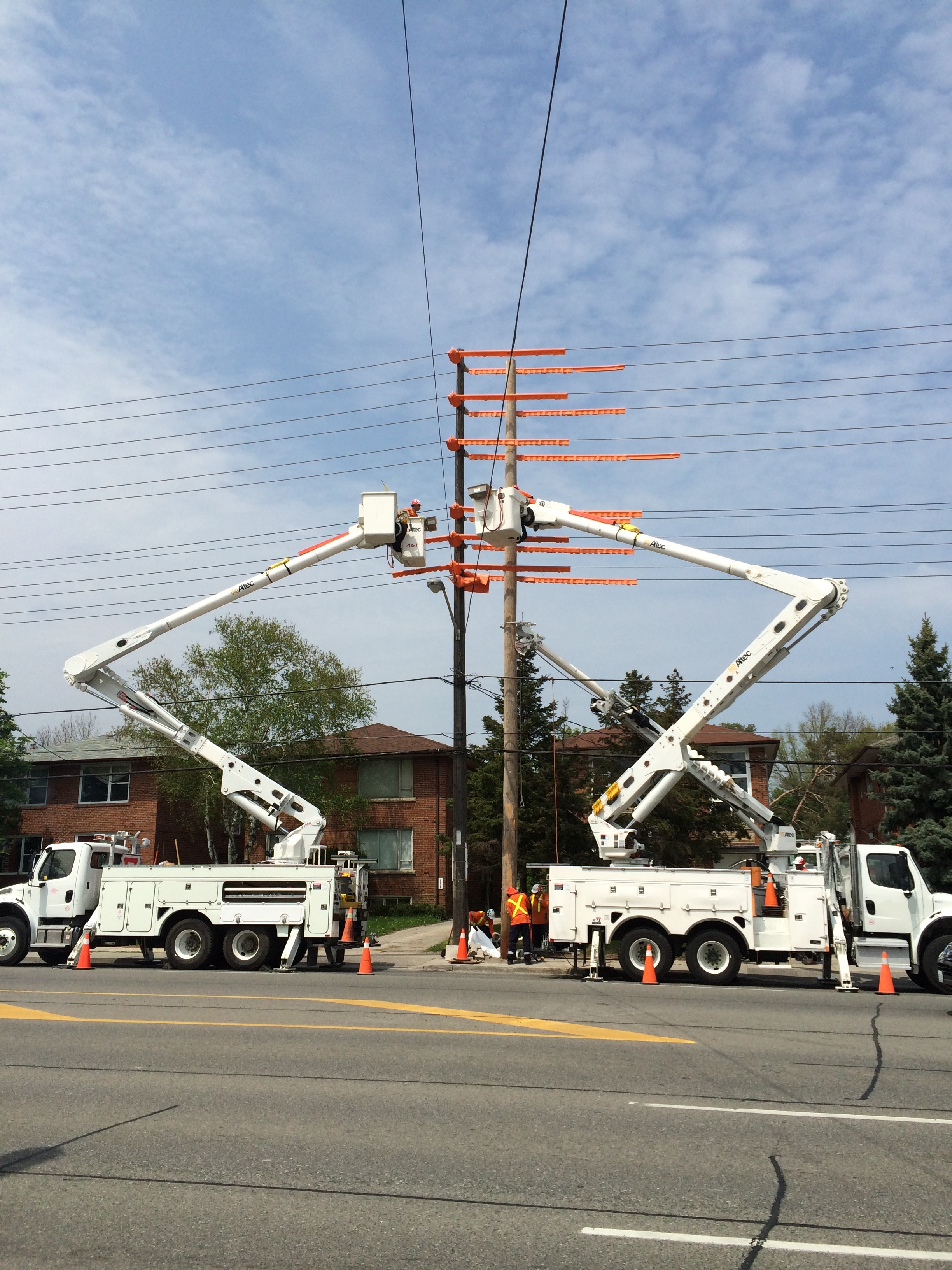 Two utilities trucks working on power lines